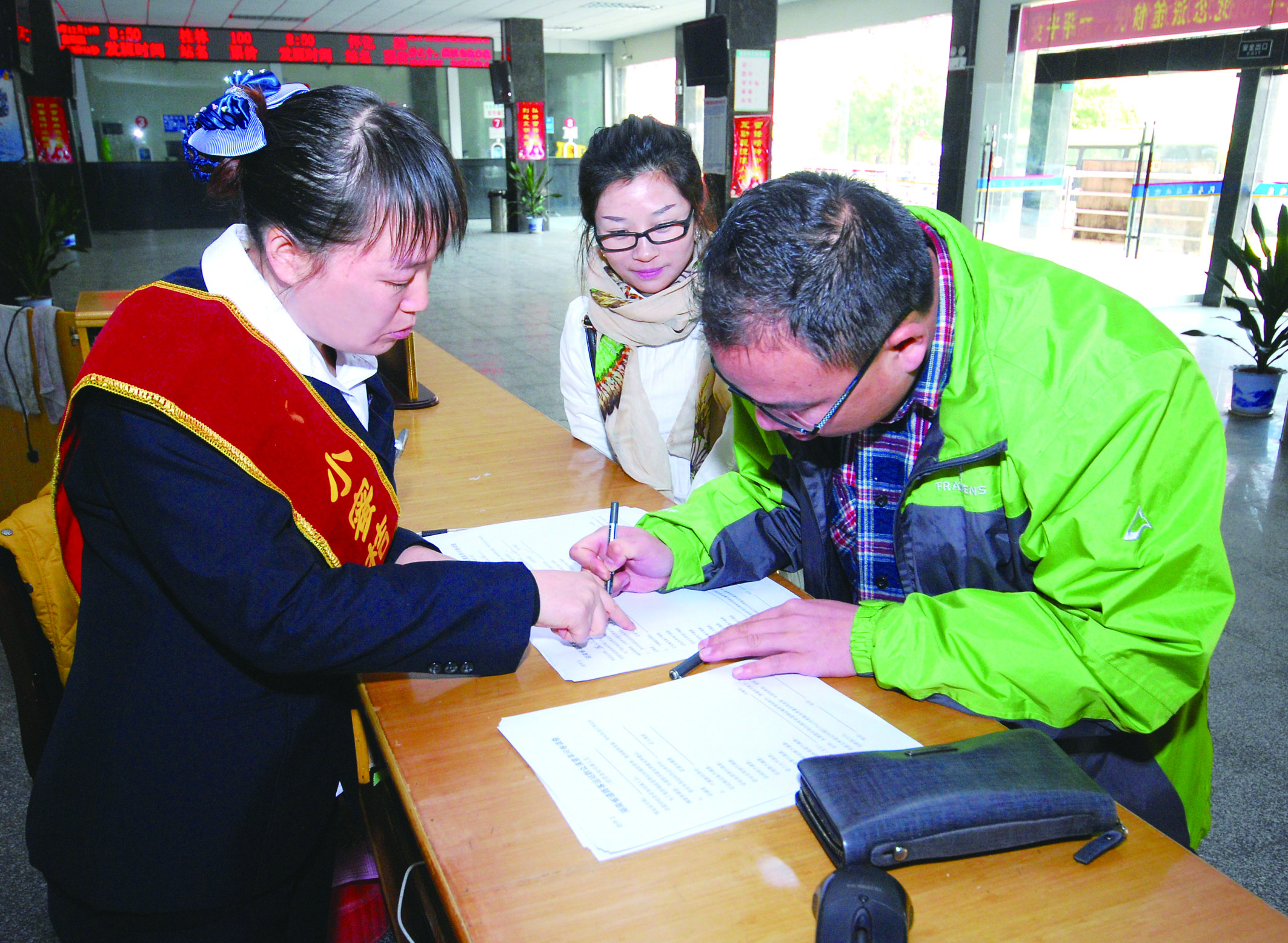 圖為洞口汽車總站站務(wù)人員在熱心為旅客服務(wù)。